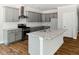 Updated kitchen with granite counters, stainless steel appliances, gray cabinets and hardwood floors at 3328 Leaflet Church Rd, Broadway, NC 27505