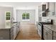 Well-designed kitchen with granite counters, stainless steel appliances, gray cabinets and hardwood floors at 3328 Leaflet Church Rd, Broadway, NC 27505