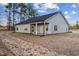 The rear of a home featuring a covered patio, multiple windows, and a well-maintained lawn at 3328 Leaflet Church Rd, Broadway, NC 27505