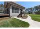 Backyard of home showing the gray exterior, black trim, deck, and sidewalk leading to lawn at 3601 Bivins Rd, Hillsborough, NC 27278