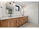 Luxurious bathroom featuring double sinks, quartz countertop, custom wood cabinetry, and modern lighting fixtures at 3601 Bivins Rd, Hillsborough, NC 27278