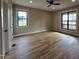 Spacious bedroom with hardwood floors, a ceiling fan, and windows with black trim at 3601 Bivins Rd, Hillsborough, NC 27278