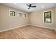 Spacious bedroom featuring hardwood floors, a ceiling fan, and three windows providing ample natural light and a view at 3601 Bivins Rd, Hillsborough, NC 27278