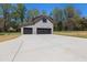 View of gray detached garage with two black doors and extra parking on the long driveway at 3601 Bivins Rd, Hillsborough, NC 27278