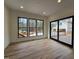 Bright living room with hardwood floors, three large windows, and a sliding door to the outdoor deck at 3601 Bivins Rd, Hillsborough, NC 27278