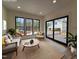 Virtually staged living room with natural colors, hardwood floors, large windows, and sliding glass door at 3601 Bivins Rd, Hillsborough, NC 27278
