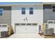 Townhome exterior featuring a white garage door and grey siding at 3717 Rosebush Dr, Zebulon, NC 27597
