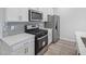 Modern kitchen features stainless steel appliances, white cabinets, and a gray backsplash at 3717 Rosebush Dr, Zebulon, NC 27597