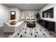 Bright living room with a comfortable sofa, geometric rug, and natural light from the large windows at 3719 Rosebush Dr, Zebulon, NC 27597