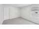 This bedroom features gray carpet, a window with blinds, and fresh paint at 3825 Rosebush Dr, Zebulon, NC 27597