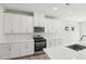 Contemporary kitchen boasts white cabinets, stainless steel appliances, and quartz countertops at 3825 Rosebush Dr, Zebulon, NC 27597