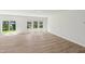 Spacious living room with wood-look flooring, white walls, and natural light from sliding glass doors at 3825 Rosebush Dr, Zebulon, NC 27597