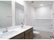 Bathroom with double sinks, a shower-tub combo with white subway tile, and brushed metal fixtures at 3829 Rosebush Dr, Zebulon, NC 27597