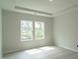 Bright bedroom featuring tray ceiling, recessed lighting and large windows showcasing the outdoor view at 3829 Rosebush Dr, Zebulon, NC 27597