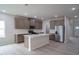 Open kitchen with center island, stainless steel appliances, and wood-look flooring at 3829 Rosebush Dr, Zebulon, NC 27597