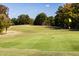 Manicured golf course with green grass, trees, and the yellow flag waving in the distance at 408 Carpels Dr, Wendell, NC 27591