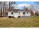 View of the back exterior with a deck and mature trees at 5144 Shield Cir, Raleigh, NC 27603