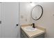 Stylish bathroom featuring a modern black faucet, round mirror, and vanity with storage at 5144 Shield Cir, Raleigh, NC 27603