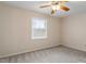 Cozy bedroom featuring neutral walls, carpet, a ceiling fan, and natural light from the window at 5144 Shield Cir, Raleigh, NC 27603