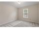 Neutral carpeted bedroom with a window providing natural light, enhancing the cozy atmosphere at 5144 Shield Cir, Raleigh, NC 27603