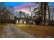 Quaint home with long driveway framed by mature trees, creating a secluded feel at 5144 Shield Cir, Raleigh, NC 27603