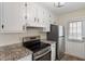 Modern kitchen featuring stainless steel appliances, granite countertops, and bright white cabinetry at 5144 Shield Cir, Raleigh, NC 27603