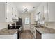 Well-lit kitchen with white cabinets, granite countertops, stainless appliances, and modern fixtures throughout at 5144 Shield Cir, Raleigh, NC 27603