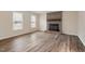 Empty living room with hardwood floors and a charming brick fireplace with a wooden mantle at 5144 Shield Cir, Raleigh, NC 27603