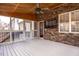 A screened-in back porch features a ceiling fan, stone wall with a tv, and access to the yard at 515 Littleport Dr, Rolesville, NC 27571