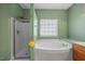 Bright bathroom featuring a separate shower, soaking tub, and green painted walls at 515 Littleport Dr, Rolesville, NC 27571
