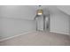 Large bedroom with neutral gray carpet, walls, and multiple entry doors at 515 Littleport Dr, Rolesville, NC 27571