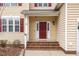 Inviting front entrance with a red door, sidelights, and brick steps at 515 Littleport Dr, Rolesville, NC 27571