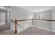 Upstairs hallway with wood railing, gray carpet, a chandelier, and natural light at 515 Littleport Dr, Rolesville, NC 27571