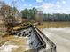 Aerial view of a dam and spillway, showcasing the beautiful landscape and water features surrounding the property at 5413 Leopards Bane Ct, Holly Springs, NC 27540