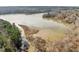 Aerial view of a lake surrounded by trees and natural vegetation at 5413 Leopards Bane Ct, Holly Springs, NC 27540