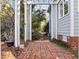 Picturesque backyard patio area featuring a pergola, brick pavers, and mature landscaping at 5413 Leopards Bane Ct, Holly Springs, NC 27540