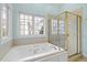 Bathroom featuring a jacuzzi tub, separate shower, and large window at 5413 Leopards Bane Ct, Holly Springs, NC 27540