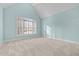 Bright bedroom featuring a vaulted ceiling and a large window for natural light at 5413 Leopards Bane Ct, Holly Springs, NC 27540