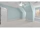 Spacious carpeted bedroom with light blue walls, vaulted ceilings, a ceiling fan, and dormer windows at 5413 Leopards Bane Ct, Holly Springs, NC 27540