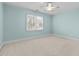 Carpeted bedroom featuring a ceiling fan and a large window with blinds at 5413 Leopards Bane Ct, Holly Springs, NC 27540