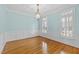Light and airy dining room with hardwood floors, wainscoting, and large windows at 5413 Leopards Bane Ct, Holly Springs, NC 27540