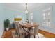 Bright dining room features a wood table, chandelier, hardwood floors, and natural light from the windows at 5413 Leopards Bane Ct, Holly Springs, NC 27540