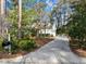 Long driveway leading to a beautiful home surrounded by lush greenery and mature trees at 5413 Leopards Bane Ct, Holly Springs, NC 27540