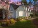 View of the home featuring light-green clapboard siding, white trim, and a landscaped yard with garden at 5413 Leopards Bane Ct, Holly Springs, NC 27540