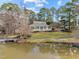 Inviting home featuring a classic wraparound porch, picturesque landscape, and waterfront access at 5413 Leopards Bane Ct, Holly Springs, NC 27540