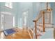 Bright foyer features hardwood floors, a staircase, and a white front door with sidelights at 5413 Leopards Bane Ct, Holly Springs, NC 27540
