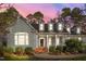 Charming home featuring light-green clapboard siding, white trim, brick accents, and a landscaped front yard at 5413 Leopards Bane Ct, Holly Springs, NC 27540