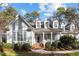Charming home featuring light-green clapboard siding, white trim, brick accents, and a landscaped front yard at 5413 Leopards Bane Ct, Holly Springs, NC 27540