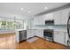 Well-lit kitchen featuring white cabinets, stainless steel appliances, and hardwood floors at 5413 Leopards Bane Ct, Holly Springs, NC 27540