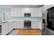 Modern kitchen with white cabinets, stainless steel appliances, and hardwood floors at 5413 Leopards Bane Ct, Holly Springs, NC 27540
